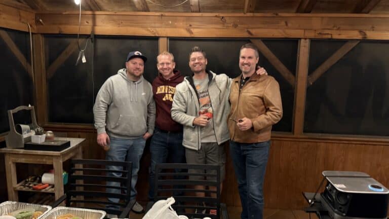 Friends enjoying a casual gathering in a cozy, wood-paneled room with snacks and drinks.